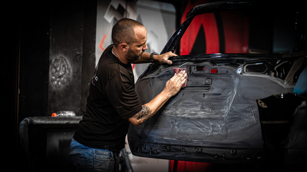 Maranello Collision technician tending to vehicle damage in South Miami.