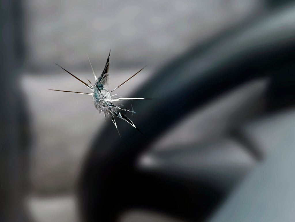Close up of a chip in the windshield of a car on the driver’s side.